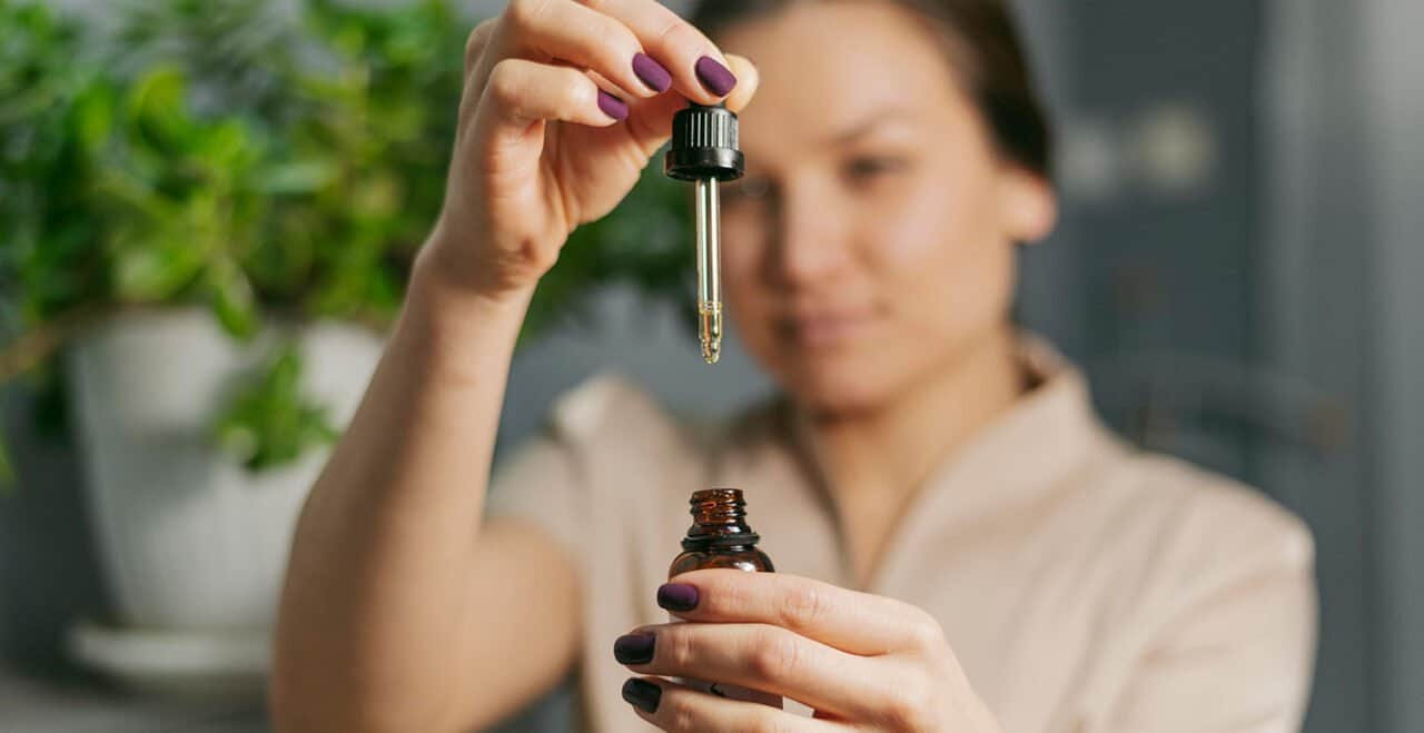 young lady using CBD tincture